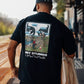Manuel Store black 100% cotton heavyweight t-shirt with a graphic print of two large hands with clouds and a city landscape.
