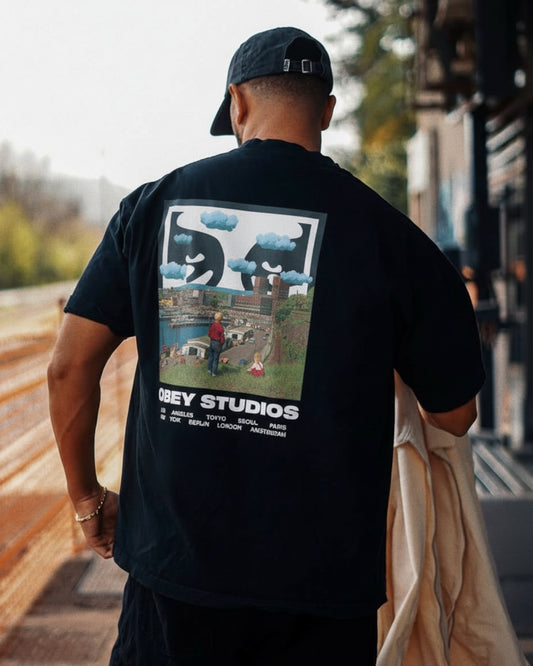Manuel Store black 100% cotton heavyweight t-shirt with a graphic print of two large hands with clouds and a city landscape.