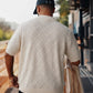 Manuel Store cream knit polo shirt with short sleeves, diamond pattern, and ribbed collar and hem.