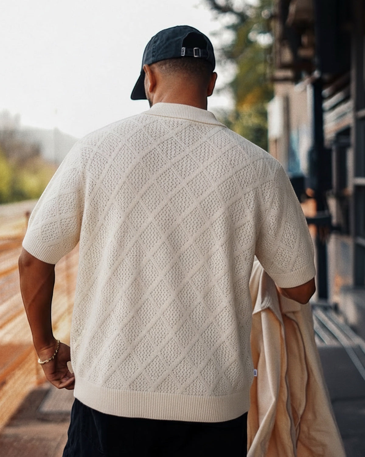Manuel Store cream knit polo shirt with short sleeves, diamond pattern, and ribbed collar and hem.