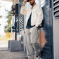 Manuel Store off-white cotton twill workwear jacket and drawstring pants worn by a man with a cap.