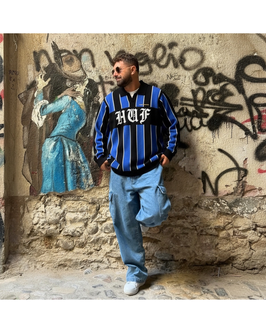 Manuel Store black, blue, and white striped knit sweater with HUF logo and embroidered chest detail.