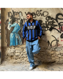 Manuel Store black, blue, and white striped knit sweater with HUF logo and embroidered chest detail.