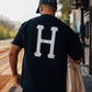 Manuel Store black 100% cotton t-shirt with large white HUF Classic H logo on back and left chest.