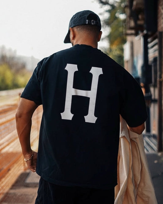 Manuel Store black 100% cotton t-shirt with large white HUF Classic H logo on back and left chest.