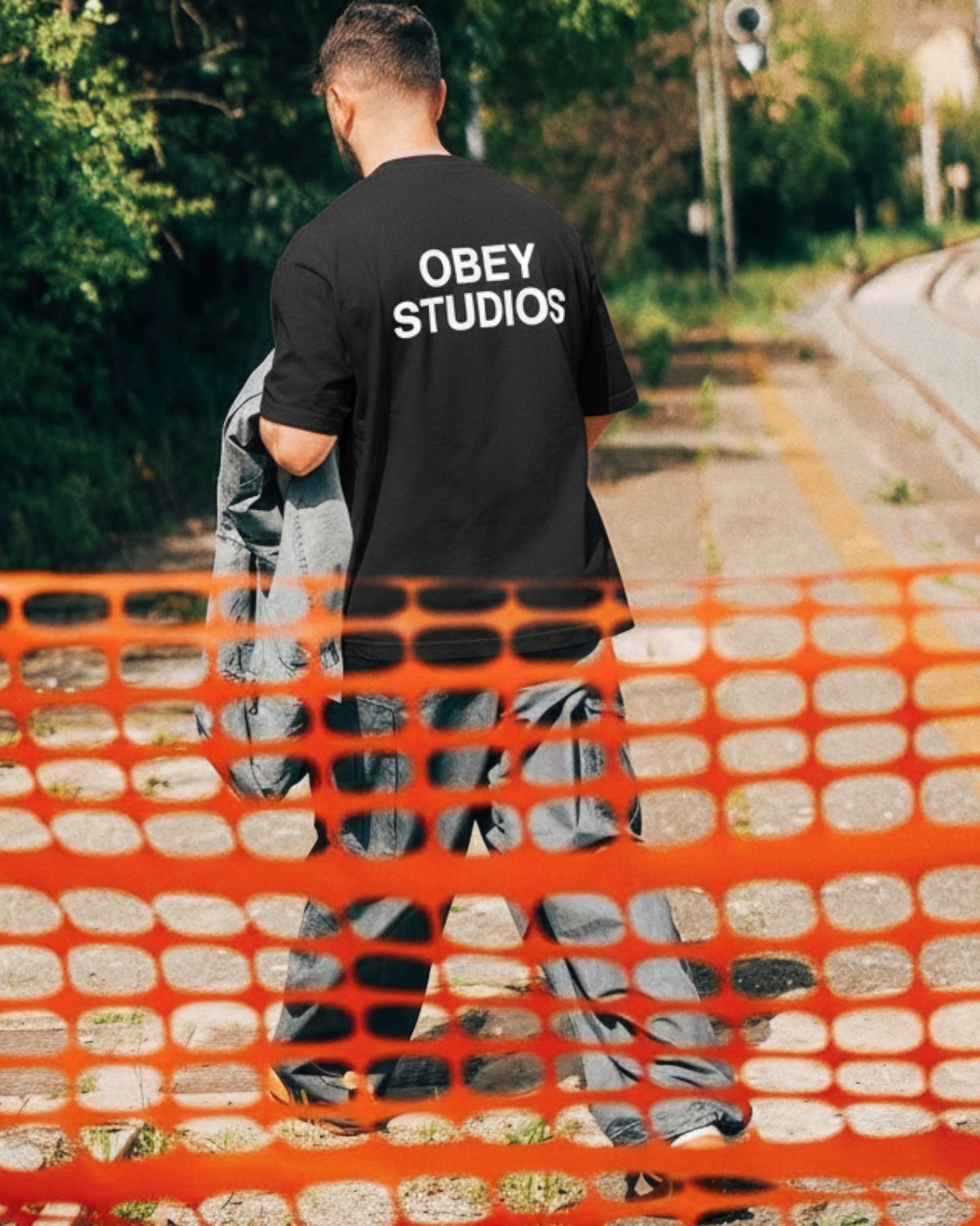 Manuel Store black heavyweight 100% cotton t-shirt with "OBEY STUDIOS" graphic print on back.