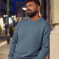 Manuel Store blue crewneck sweater with embossed HUF logo on chest, ribbed collar, cuffs, and hem.