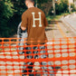 Manuel Store brown 100% cotton t-shirt with large cream 'H' logo on back. Short sleeves, crew neck.