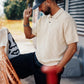 Manuel Store cream knit polo shirt with diamond pattern, short sleeves, and buttoned collar.