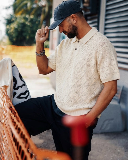 Manuel Store cream knit polo shirt with diamond pattern, short sleeves, and buttoned collar.