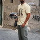 Manuel Store beige 100% cotton t-shirt with two Dalmatians kissing graphic and "HUF Worldwide" text.