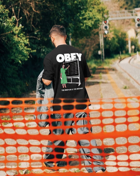 Manuel Store black 100% cotton t-shirt with OBEY graphic and "The Medium is the Message" text.
