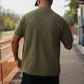 Manuel Store olive green short-sleeve knit polo shirt with diamond pattern and ribbed collar, cuffs, and hem.