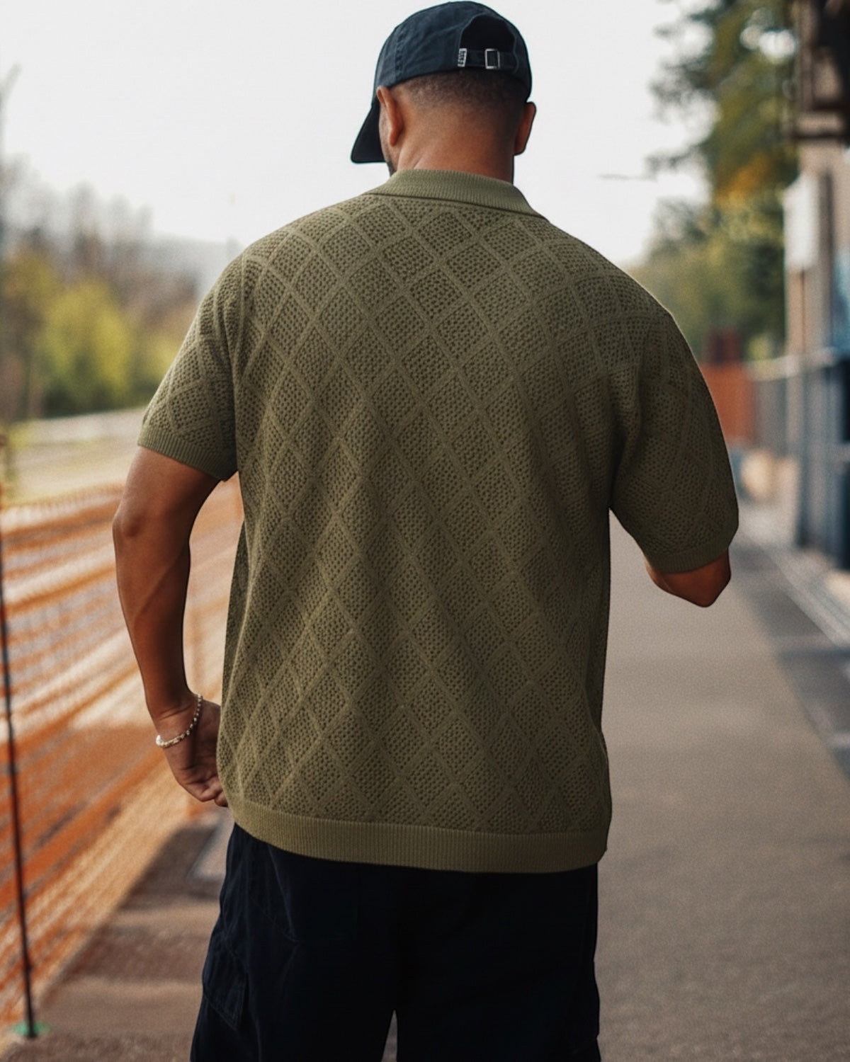 Manuel Store olive green short-sleeve knit polo shirt with diamond pattern and ribbed collar, cuffs, and hem.