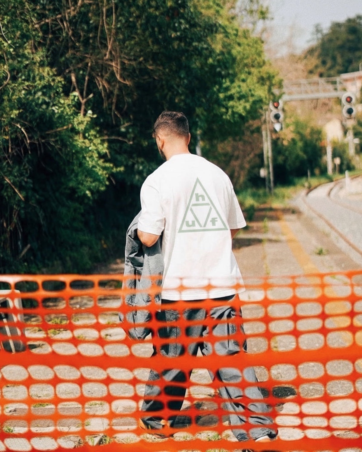 Manuel Store white 100% cotton t-shirt with a light green triple triangle HUF graphic on the back.