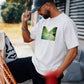 Manuel Store white 100% cotton t-shirt with a printed graphic of a skateboarder on a road between mountains.