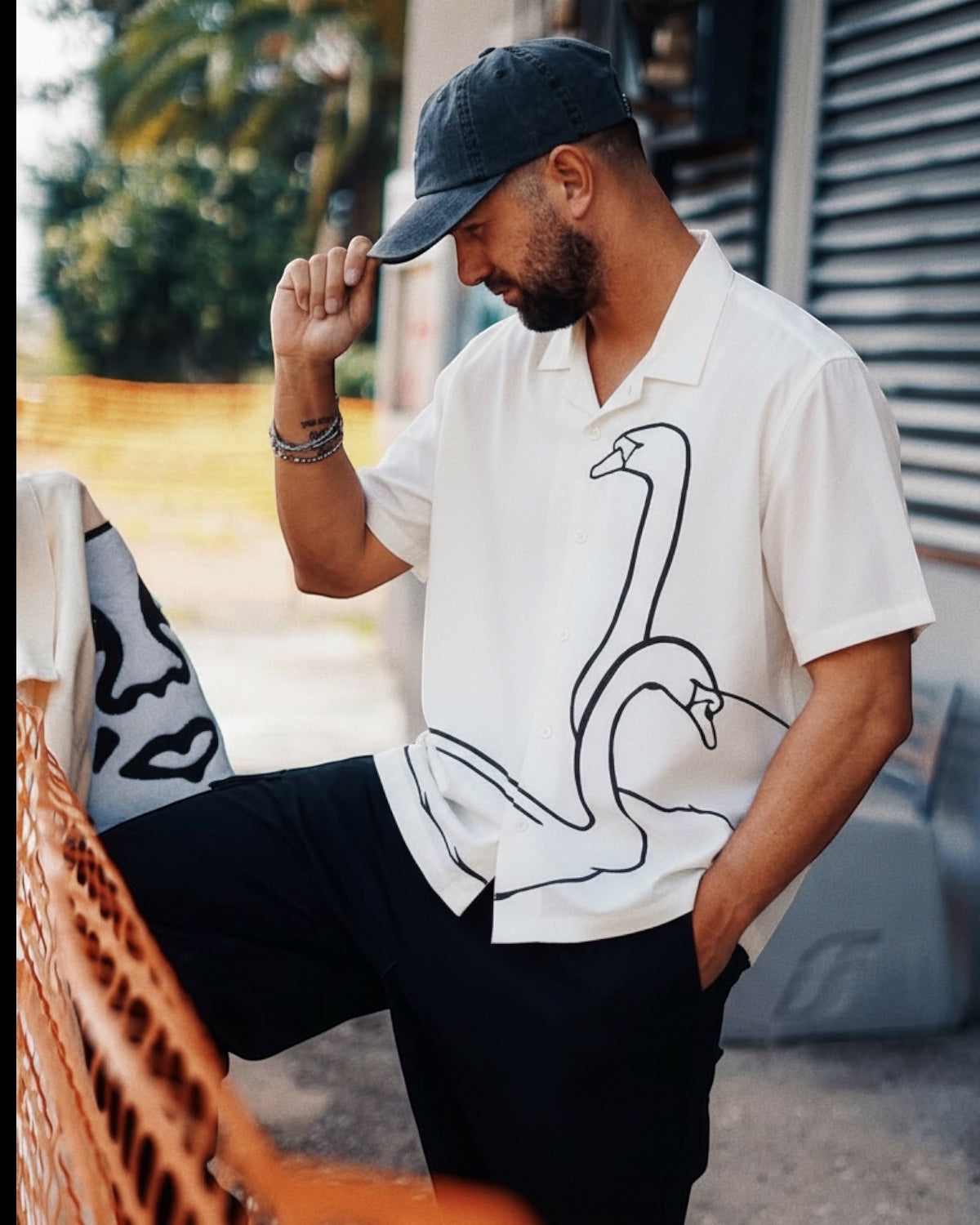 Manuel Store white short-sleeve cotton-linen blend shirt with black swan graphic print and button closure.